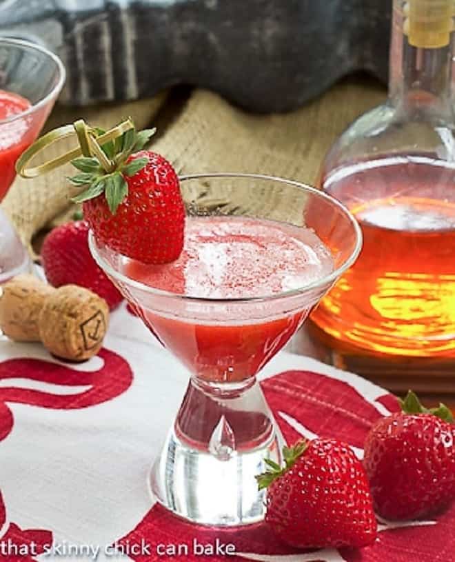 A Strawberry Bellini in a small martini glass garnished with fresh strawberries.