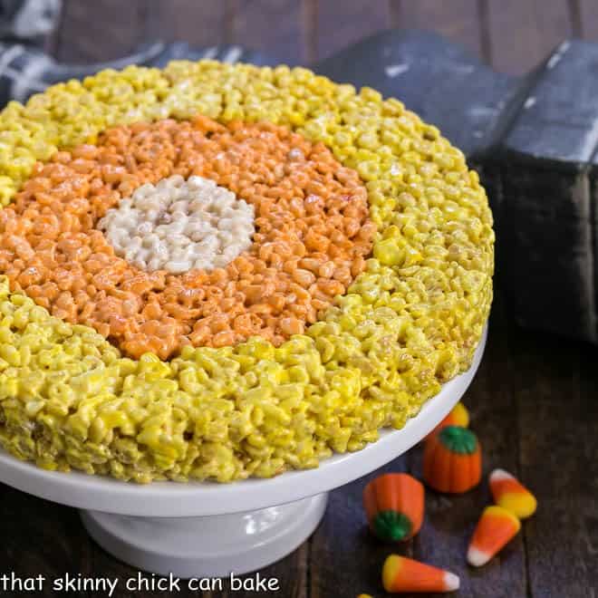 Uncut Candy Corn Rice Krispie Treats on a cake stand.