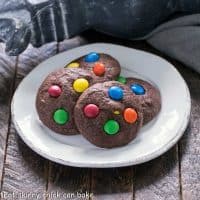 4 brownie cookies with M&Ms on a white dessert plate