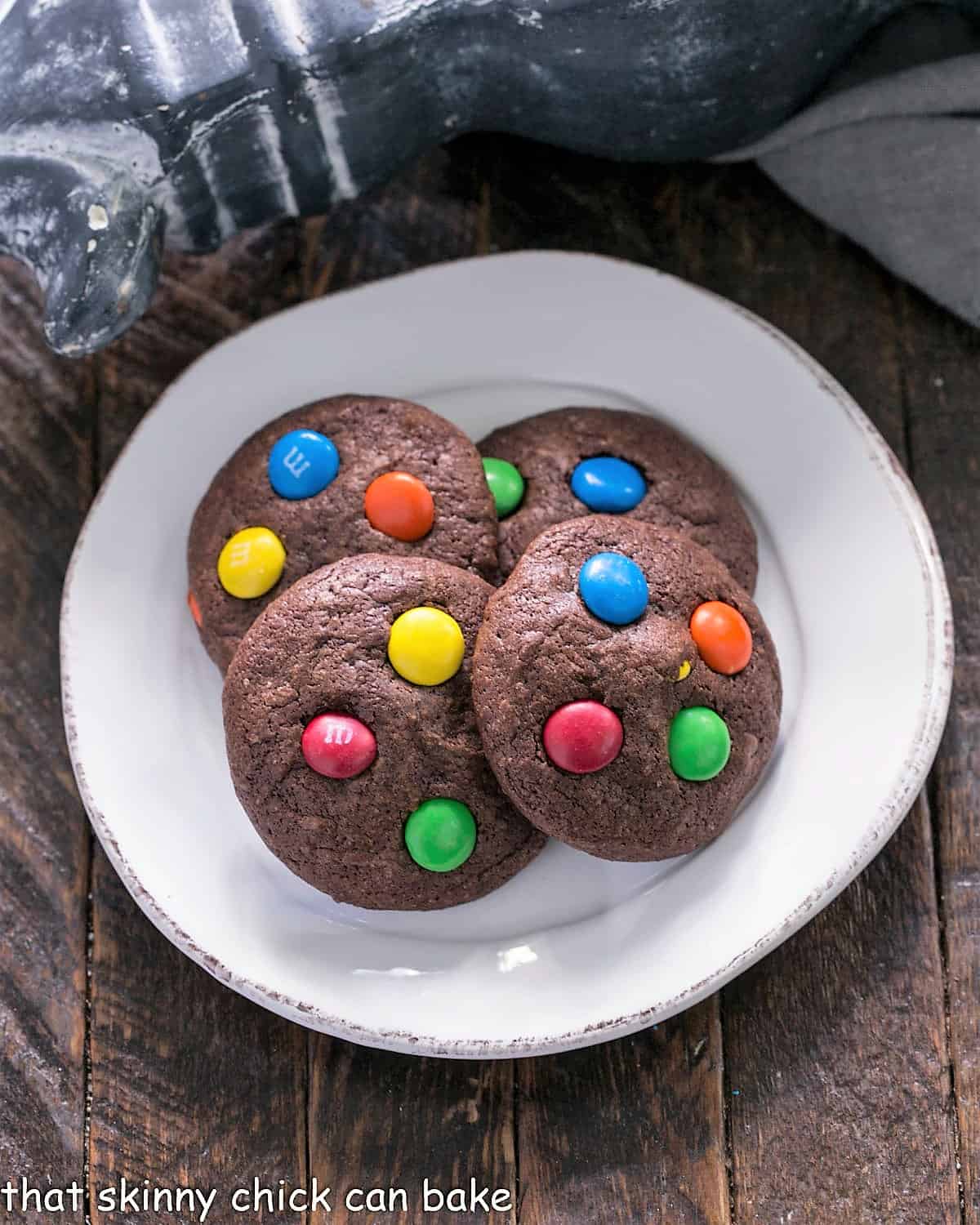 Overhead view of 4 Brownie cookies on a round white plate.