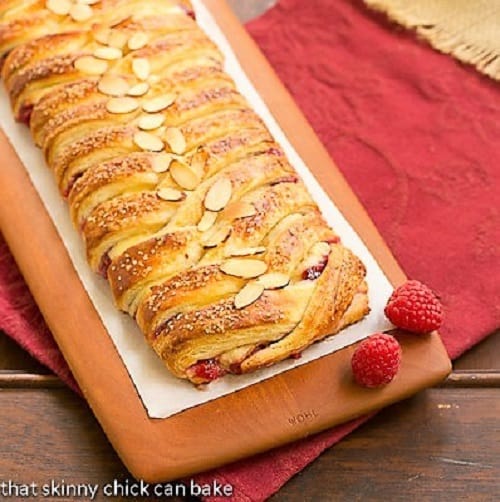 Raspberry Danish Braid on a wooden cutting board.