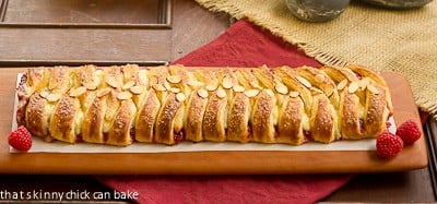 Horizontal view of Raspberry Danish Braid on a cutting board.