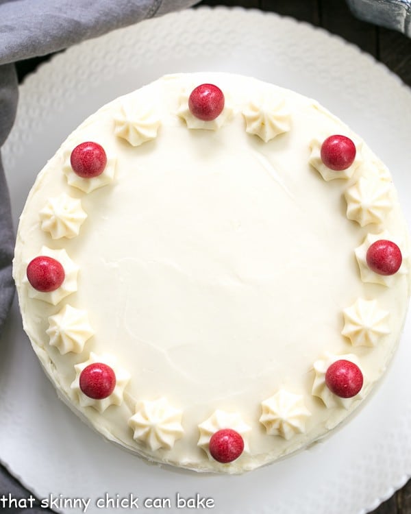 Overhead view Red Velvet Cake with White Chocolate Cream Cheese Frosting on a white cake plate.