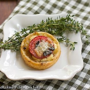Tomato and Boursin Tartlet on a square white plate with fresh thyme