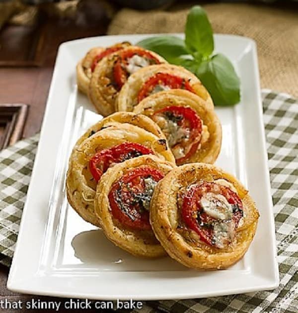 Tomato and Boursin Tartlets on a white ceramic tray.