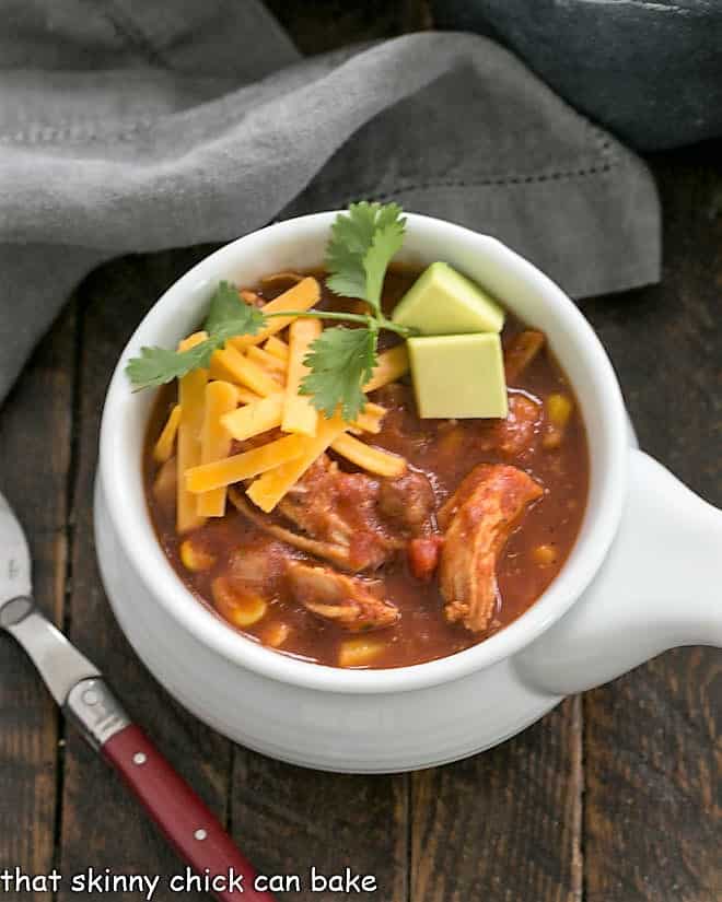 Overhead view of chicken tortilla soup in a white soup bowl.