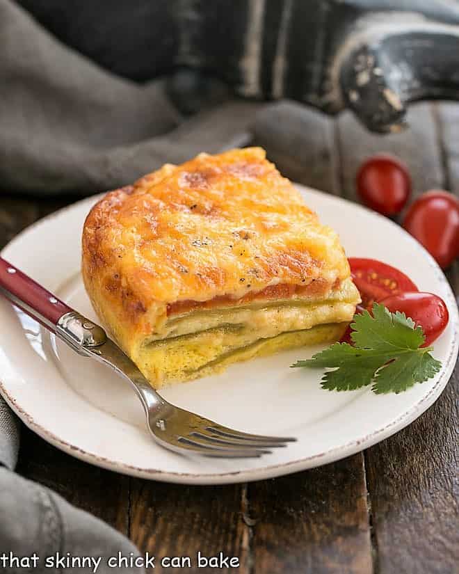 Chili Relleno Casserole slice on a round white place with a red handled fork.