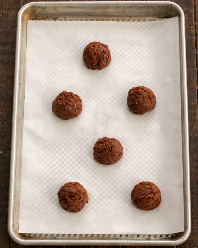 Chocolate cookie dough scooped onto a prepared baking sheet.