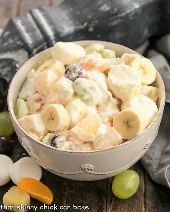 Holiday fruit salad in a white serving bowl.