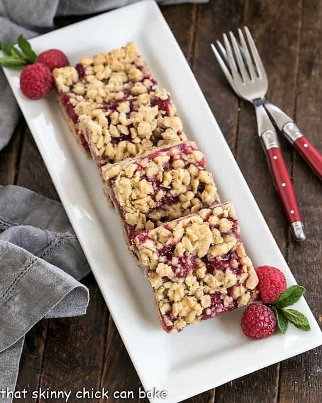 Overhead view of raspberry oatmeal bars on a whie serving tray