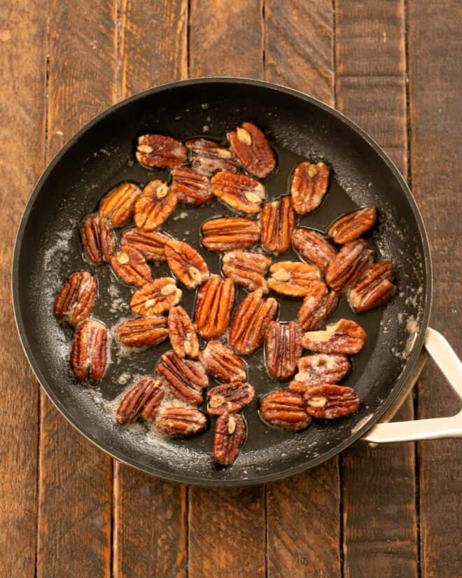 Candied pecans in a skillet.