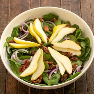 Overhead view of Spinach and Pear Salad in a serving bowl.