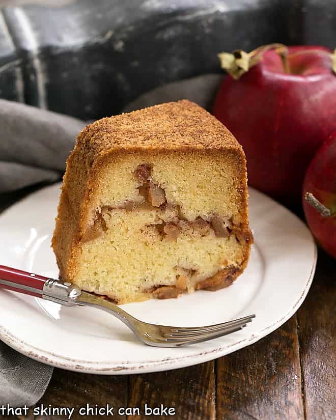 Slice of Cinnamon Apple Bundt Cake on a white plate with a red handled fork