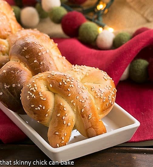 Homemade Challah Pretzels covered with sesame seeds on a white tray