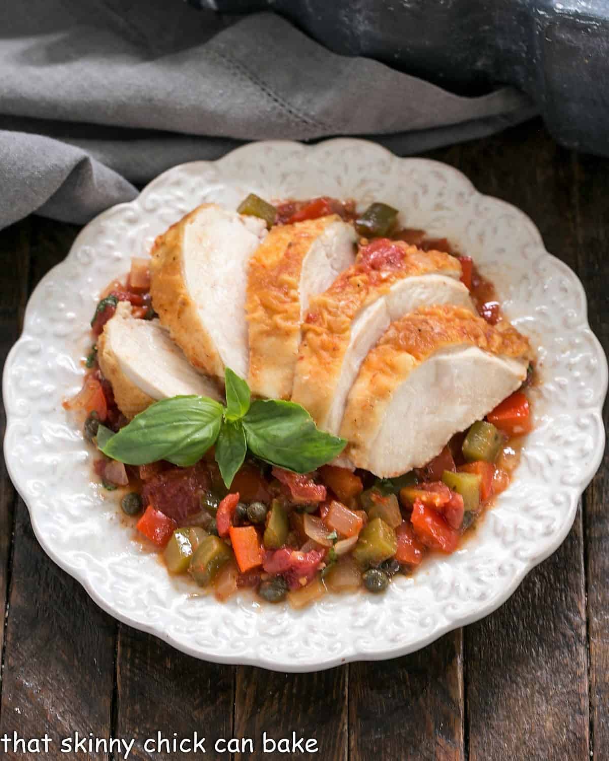 Overhead view of Chicken Cacciatore fanned on a decorative white plate.