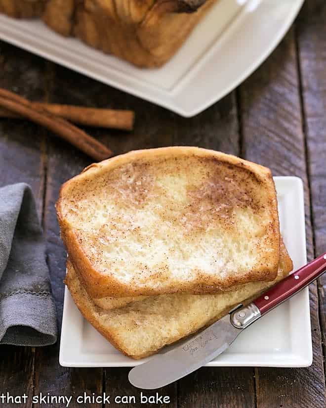 Cinnamon Pull Apart Bread slices on a square white plate with a small knife