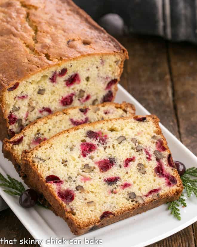 Slices of cranberry pecan quick bread on a white tray.