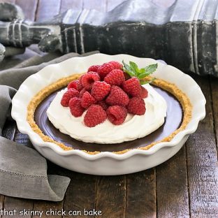 side view of chocolate satin pie in a white pie plate