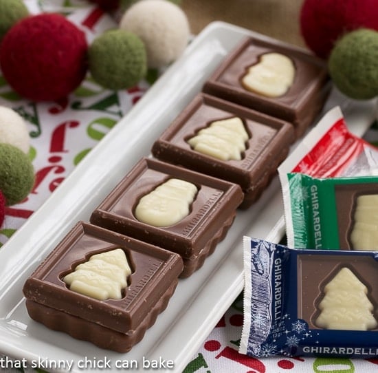 Festive Fudge Snowflakes and Squares on a white rectangular tray.