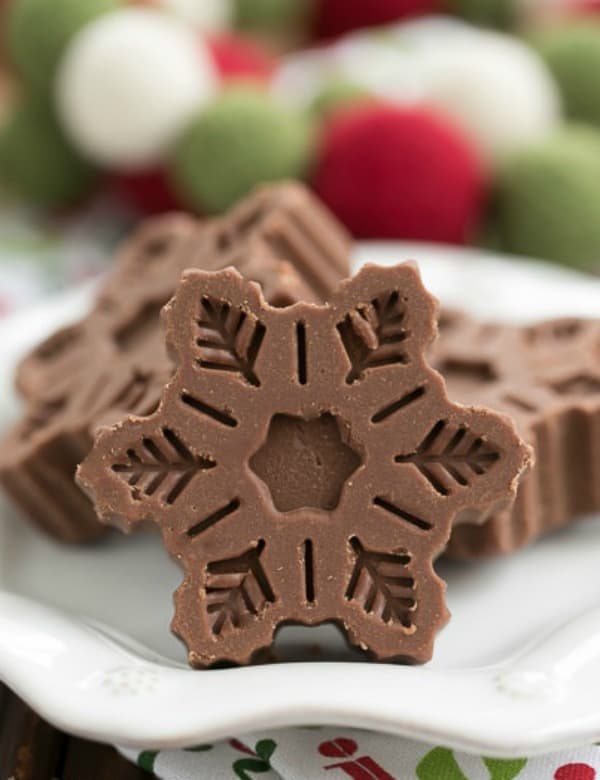 Festive Fudge Snowflakes on a white plate.