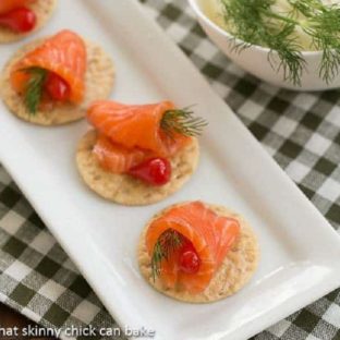 Dilled Gravlax on crackers on a white tray