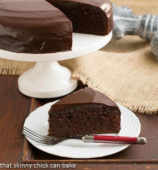 One Layer Fudge Cake with a rich chocolate ganache topping on a white dessert plate.