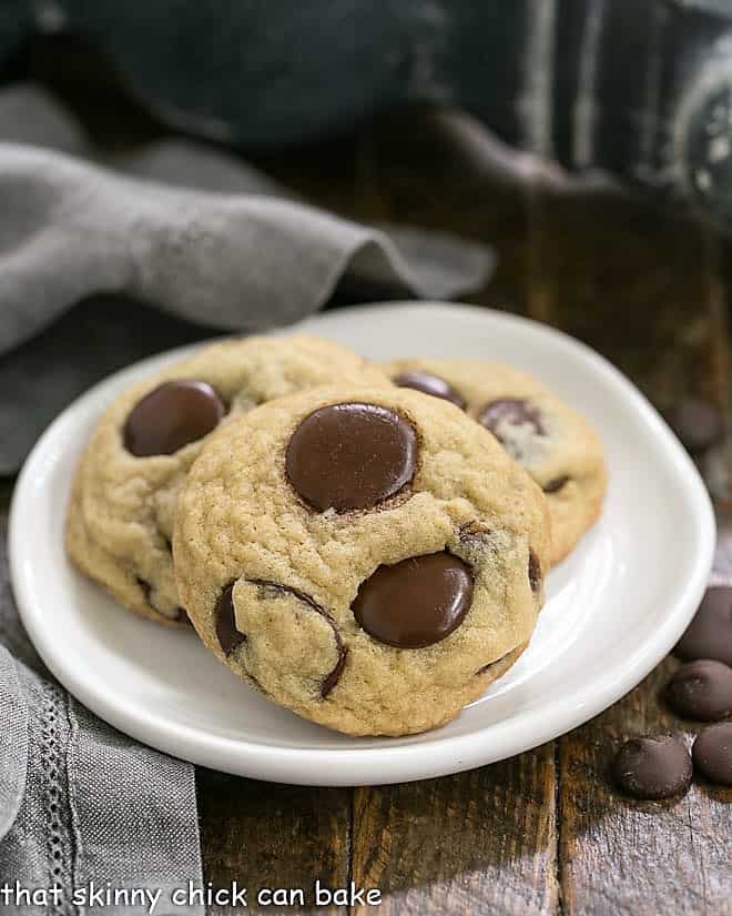 Three Chewy chocolate chunk Cookies on a round white dessert plate