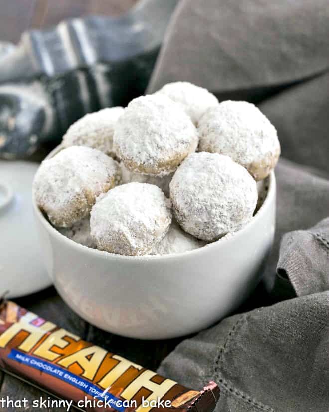 Mexican Wedding Cookies with Toffee bits in a white serving bowl.