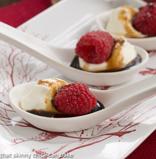 Closeup view Balsamic Raspberries with Mascarpone Cream in white Chinese soup spoons