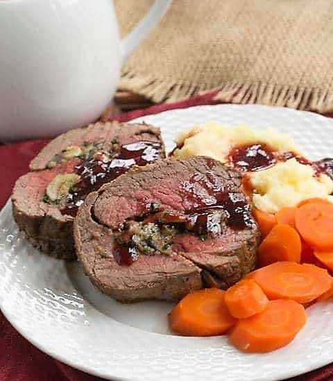 Beef Tenderloin with Gorgonzola Sauce on a white dinner plate