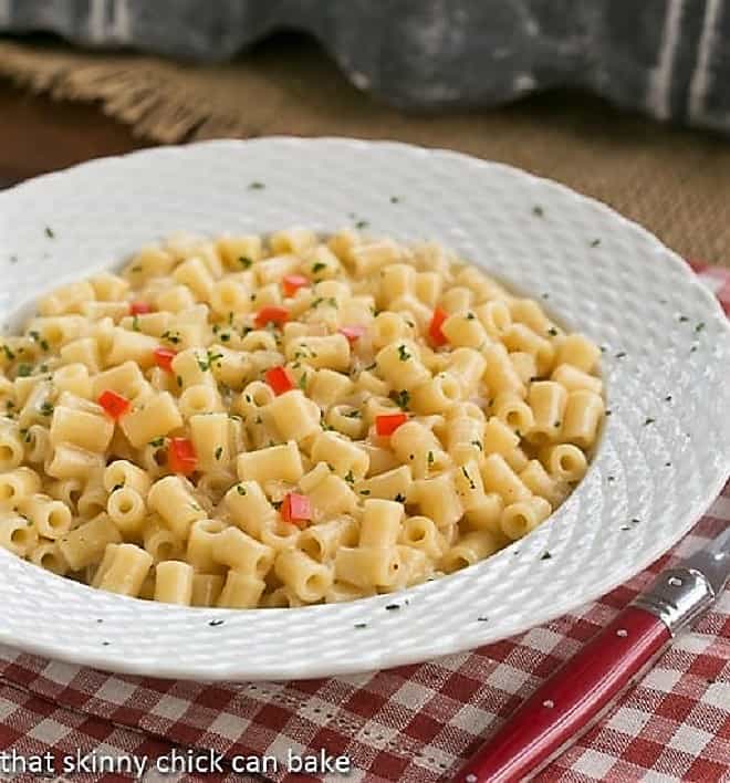 Bowl of pasta risotto with a red handled fork on a checkered napkin