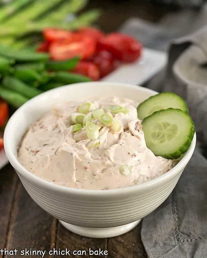 Sun-Dried Tomato Dip in a white bowl with a tray of fresh vegetables.