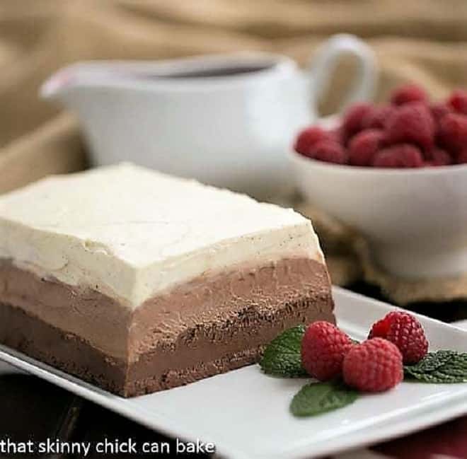 Triple Chocolate Terrine on a white platter with raspberries and mint