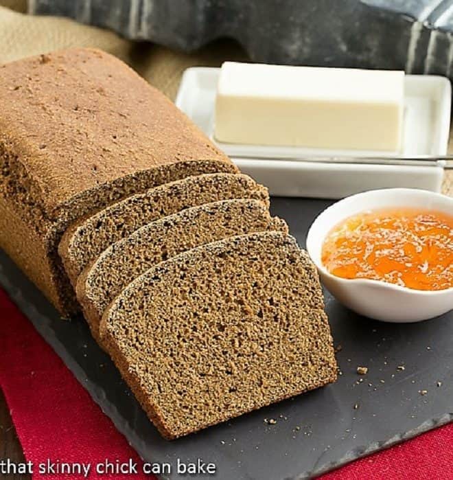 Whole Wheat Molasses Quick Bread, sliced on a slate tray with a bowl of jam and butter