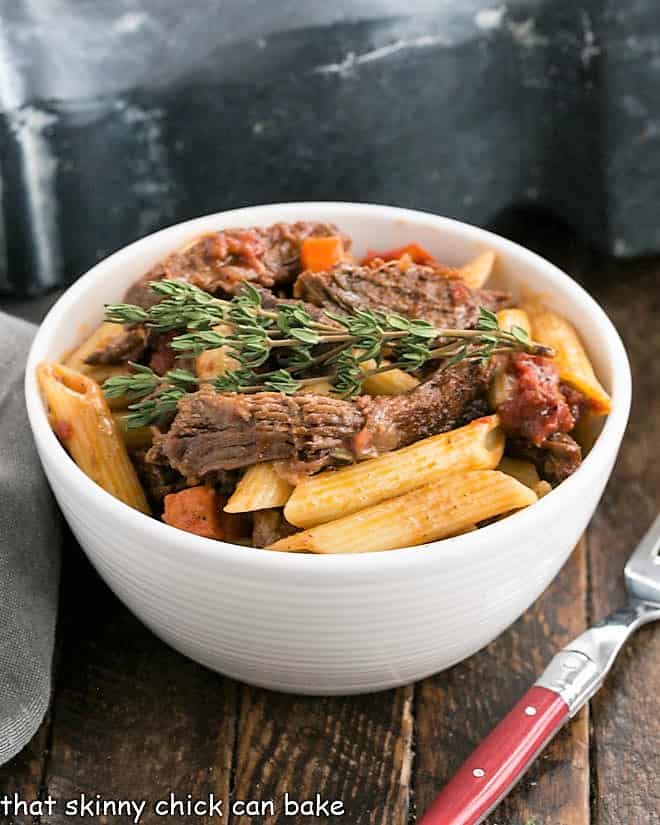 Beef Burgundy pasta in a white bowl with a fork