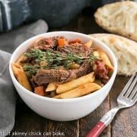 Beef Burgundy Pasta in a small white bowl with a red handled fork