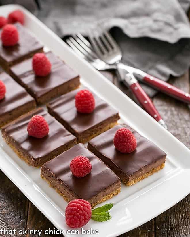 Dark Chocolate Dessert Bars on a white tray garnished with raspberries and mint