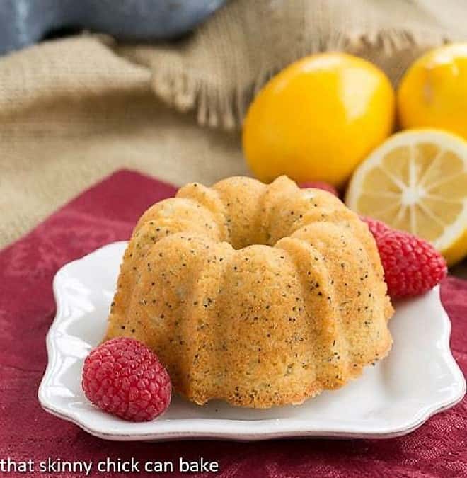 Meyer Lemon Tea Cake on a white dessert plate with fresh raspberry garnish