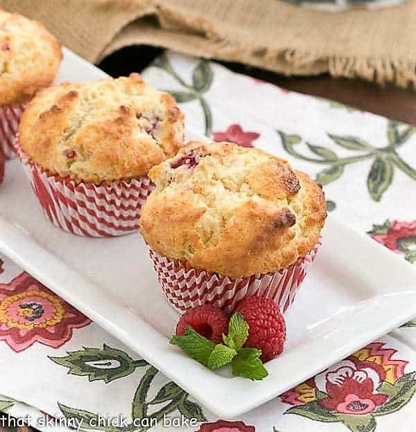 Spectacular Raspberry White Chocolate Muffins on a white rectangular platter.