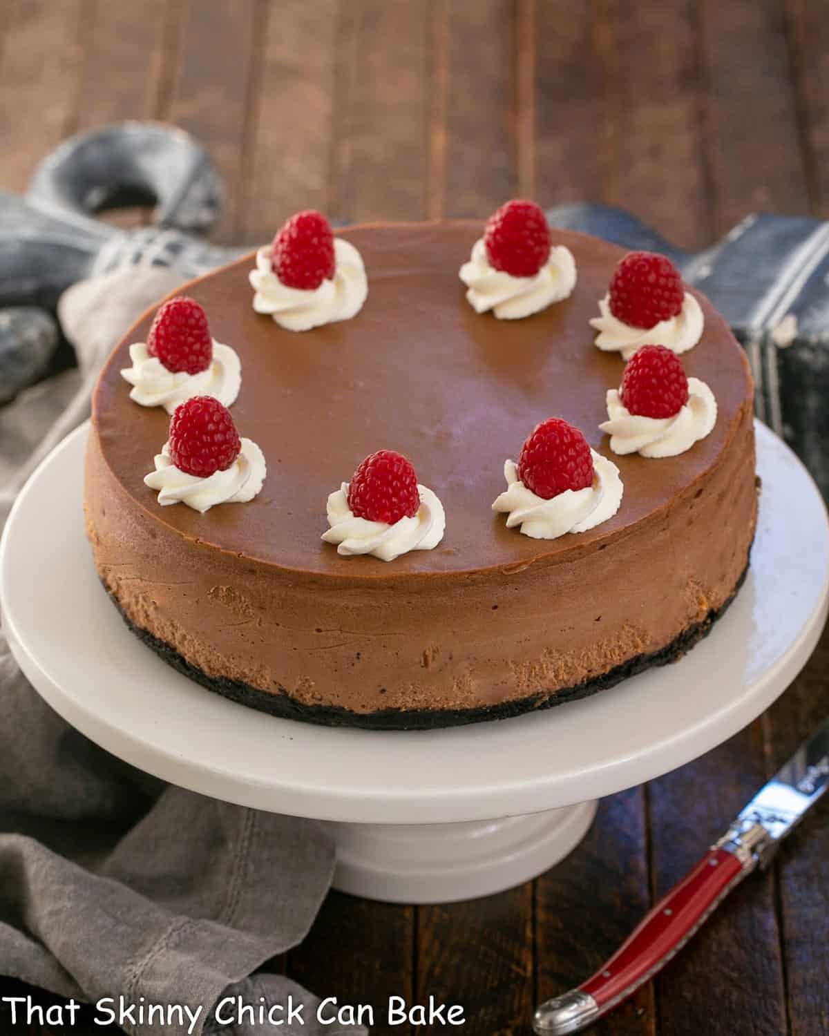 Chocolate Mascarpone Cheesecake on a white ceramic cake stand.