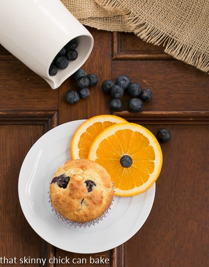 Blueberry Orange Muffin on a small white plate with orange slices and a blueberry.
