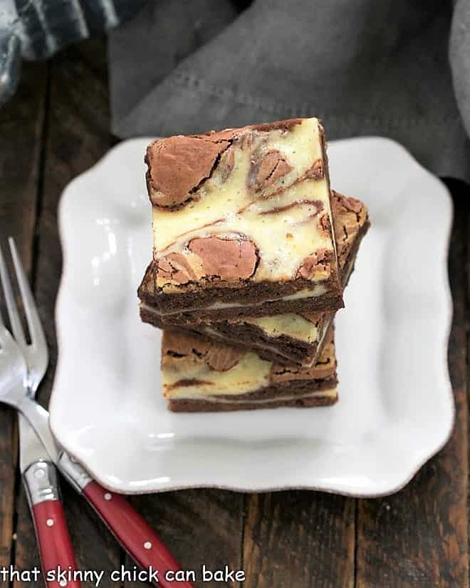 3 Cheesecake Swirl Brownies stacked on a small plate