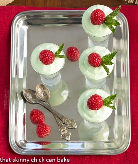 Grasshopper Moussen on a silver platter with spoons and raspberries viewed from above