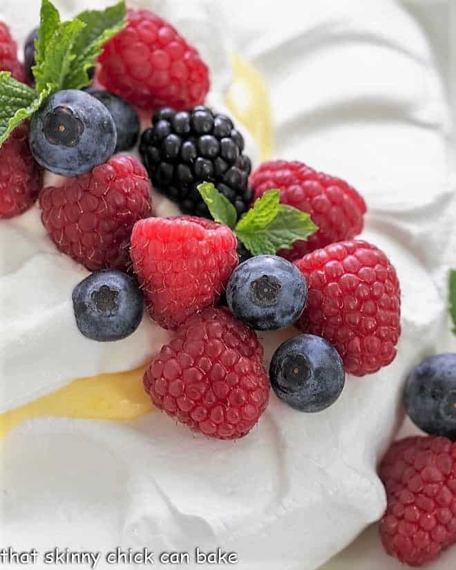 Vibrant fresh berries and mint on top of a meringue shell,