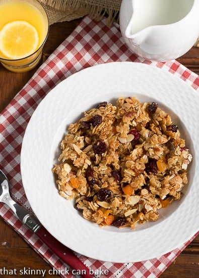 Chunky Maple Coconut Granola viewed from above in a white bowl over a red and white checked napkin