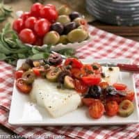 Sea Bass with Tomatoes, Olives and Capers on small square plate with fork