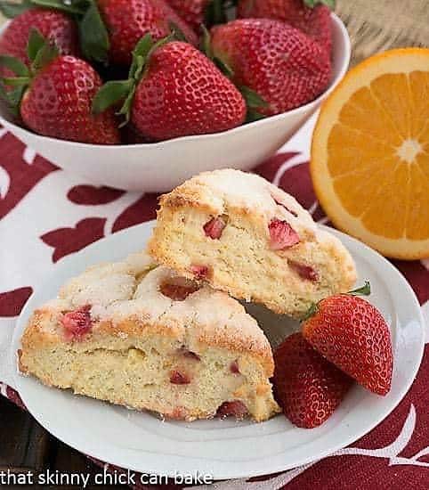 Strawberry Buttermilk Scones on a white plate with fresh strawberries.
