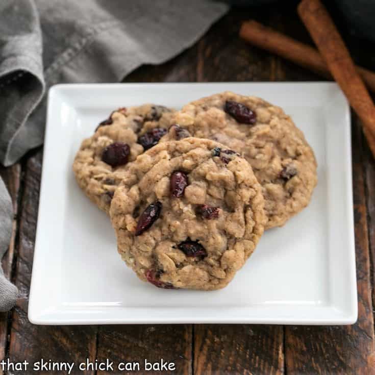 3 oatmeal craisin cookies on a white ceramic plate