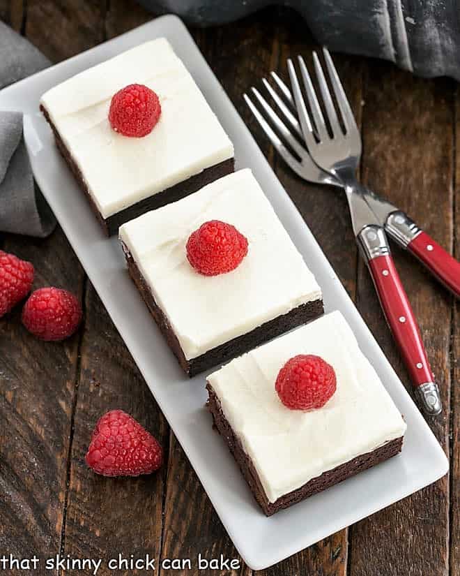 Overhead view of Raspberry Brownies with White Chocolate Icing on a white tray
