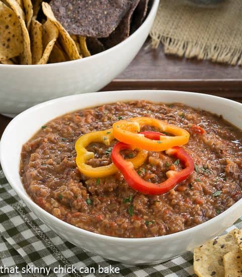 Smoky Black Bean Dip in a white bowl topped with pepper rings